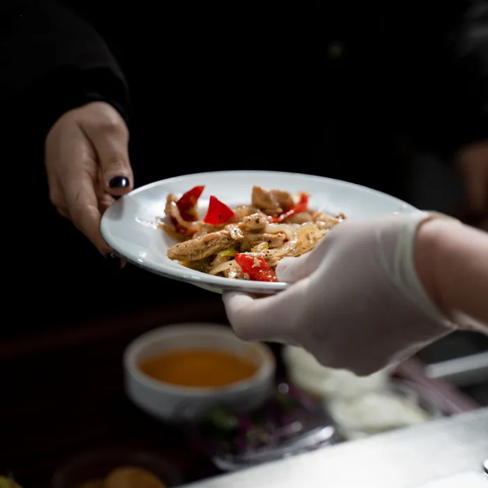 Plato de comida casera saliendo de la cocina hacia la mesa